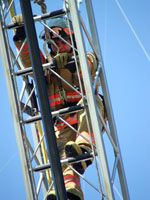 Fire fighter climbing the extended ladder of a Fire Engine