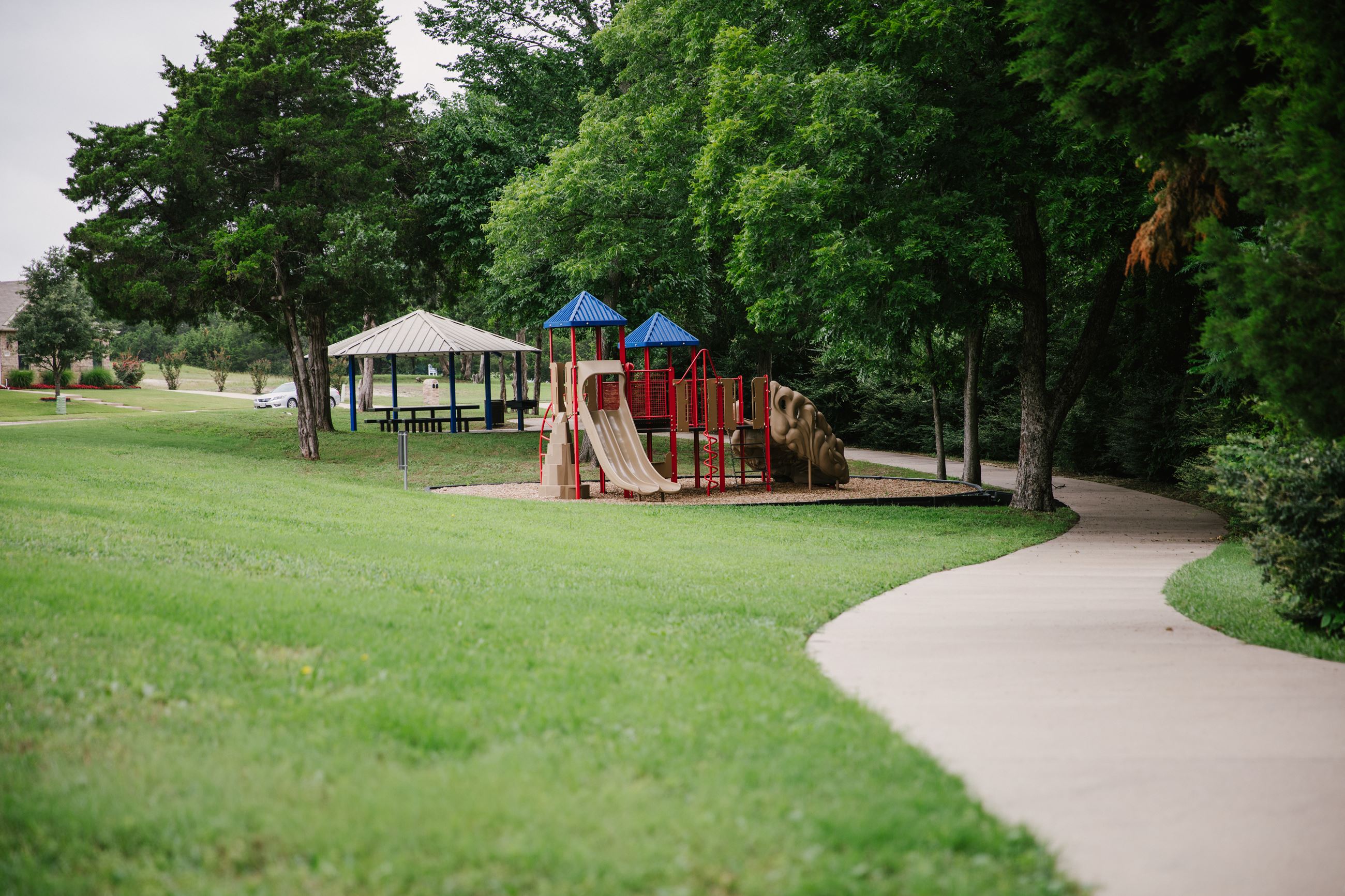 Play structure, pavilion, and trail at Wooded Creek Greenbelt